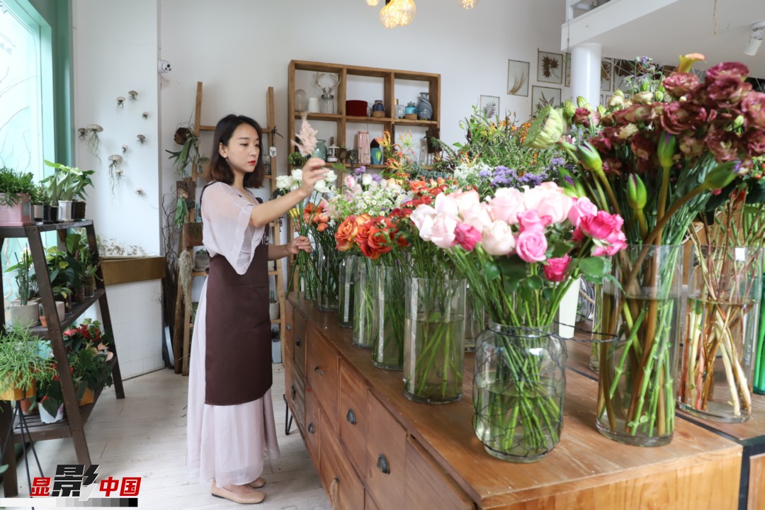 王黎媛是一名河南姑娘，在昆明念完大學(xué)后，就再也舍不下春城的藍(lán)天陽(yáng)光、青山碧水，更舍不下這里的四時(shí)繁花，于是就干脆留了下來(lái)，成了一名媒體人。2017年的時(shí)候又毅然辭去工作，創(chuàng)業(yè)開起了花店，成了都市里的一名“花房姑娘”。圖為王黎媛在自己的花店中整理鮮花。新華網(wǎng) 周亞平/攝 念新洪/文