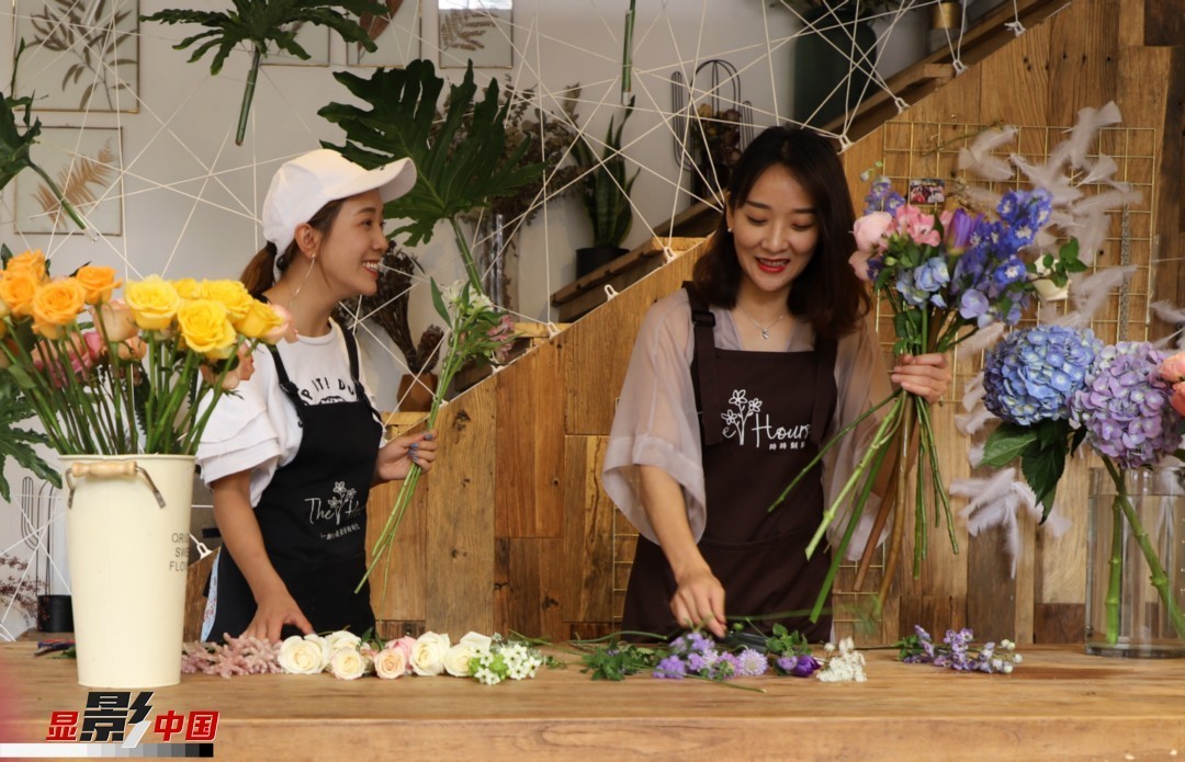 “昆明是鮮花的原產地，有亞洲最大的鮮切花交易市場，可以說具備開花店的天時地利；另外和很多女孩一樣，我從小也就有開花店的夢想！”說起當初的決定，王黎媛說一是因為夢想，另外也跟昆明這個城市產花、賣花的“基因”有關。圖為王黎媛和同事在制作花束。新華網 周亞平/攝 念新洪/文
